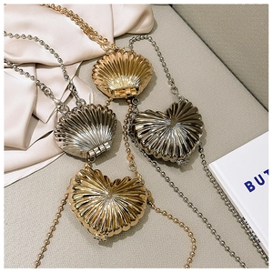 Close-up of shell and heart shaped zinc alloy mini metal bags with ball chains