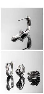 Detail of vintage silver stainless steel hoop earrings featuring feather and floral designs