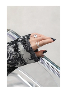 Irregular textured silver ring and crossover diamond ring set worn on a model hand