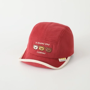 Detailed close-up of red baby cap with cartoon bear embroidery and white brim piping