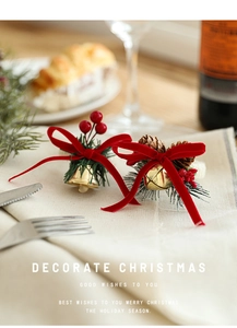 Detailed view of Christmas napkin ring with velvet bow, pine cones and golden bells