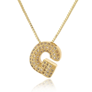Macro detail of gold-plated letter G pendant with micro-paved cubic zirconia stones