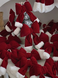 Close-up of red velvet Christmas bows with white faux fur trim for holiday tree decor