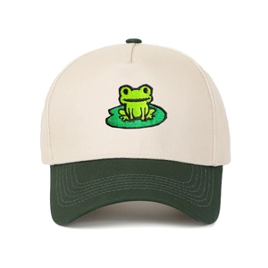 Detailed close-up of embroidered frog on a green lotus leaf on a cream trucker hat