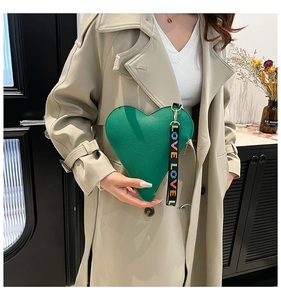 Detail of green heart-shaped leather handbag with LOVE LOVE lettered strap