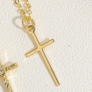 Detail view of 14K gold plated cross pendant necklace with zircon stones and polished finish