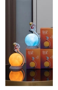 Detail of astronaut moon lamps showing blue and warm yellow light options with boxes