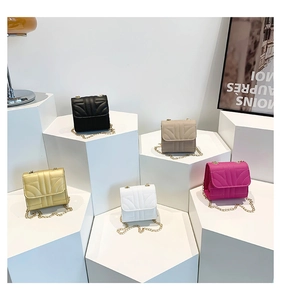 Detailed display of mini chain flap bags in multiple colors on hexagonal display stands