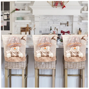 Three sequined snowman Christmas chair covers in a modern kitchen setting