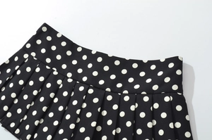 Vue détaillée de la taille plissée sur une mini-jupe à pois noirs et blancs