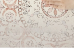 Close-up of hand touching soft vintage French mandala rug with antibacterial texture