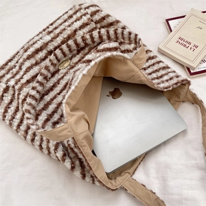 Macro shot of plush brown striped tote bag showing large capacity and soft texture