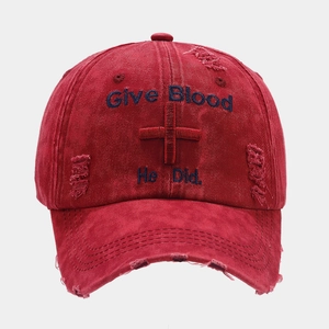 Detail of washed burgundy baseball cap featuring distressed holes and religious embroidery