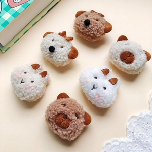Detailed view of assorted plush cartoon animal head accessories on a beige background