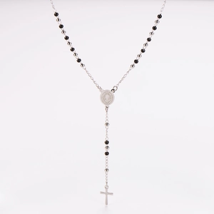 Detailed view of silver beaded rosary necklace with cross and saint medallion pendant