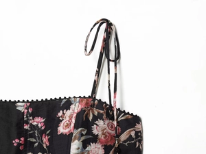 Close-up of floral print linen dress with thin straps and intricate botanical details