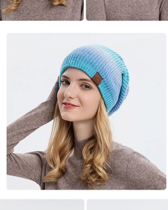 Détail du bonnet en tricot dégradé bleu violet avec écusson sport en cuir