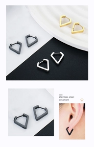 Macro detail of geometric triangle earrings in gold, silver, and black stainless steel