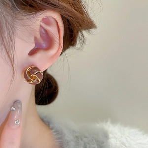 Detailed view of vintage twist stud earrings featuring brown enamel and gold plated metal