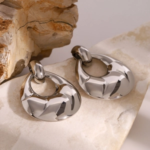 Vue macro des boucles d'oreilles goutte argentées avec finition métal sculpté