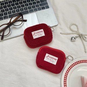 Red corduroy and plush mini coin purses with metal keychain on white aesthetic desk