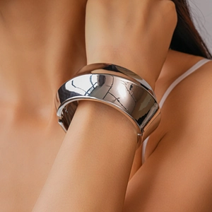 Close-up of a minimalist silver mirror-finish wide cuff bracelet on a female model