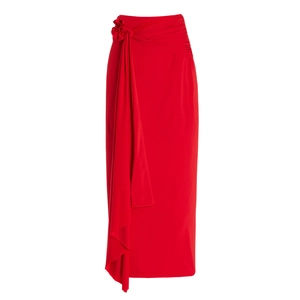 Détail d'une jupe longue rouge avec plis latéraux élégants et nœud floral décoratif