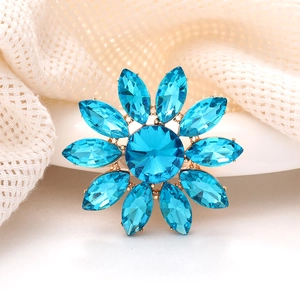 Détail de la broche fleur avec cristaux bleus et base en alliage doré élégante
