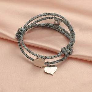 Magnetic couples heart bracelets in blue grey woven rope on pink silk background