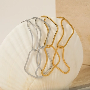 Fashionable gold and silver irregular geometric chain earrings displayed on a white shell