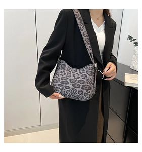 Detailed view of gray leopard print shoulder bag with matching wide strap on a model