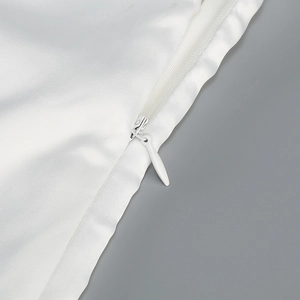 Détail de la fermeture éclair invisible et du satin blanc d'une robe de soirée