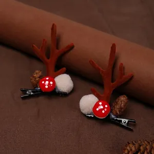 Christmas reindeer antler hair clips with red mushroom and pine cone on brown fabric