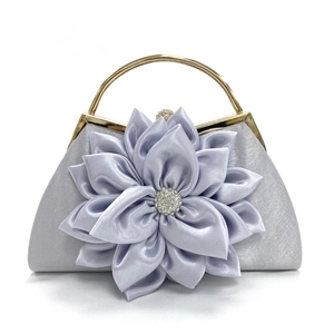 Detalle de bolso clutch de satén lavanda con flor de tela grande y centro de diamantes