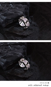 Macro detail of silver hollow heart ring with lavender enamel inlay on dark stones
