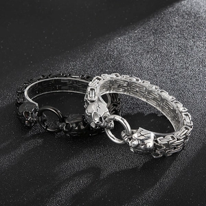 Macro detail of silver and black skull bracelets with intricate Byzantine chain links