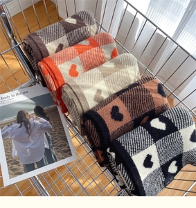 Detail of colorful knitted scarves with heart and plaid patterns in a metal cart