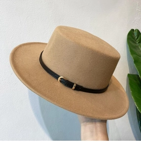 Detailed close-up of camel wool felt boater hat with a black buckle strap detail