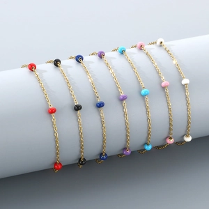 Golden stainless steel cross anklets with seven colorful enamel beads on a display stand
