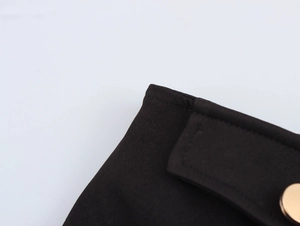 Close-up of black twill hot shorts featuring premium gold metal button and neat stitching
