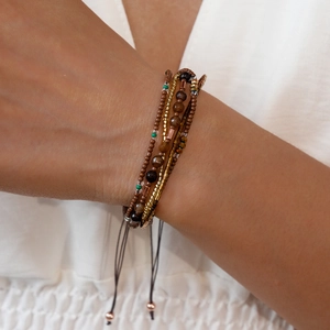Detail van een bohemien meerlaagse armband met bruine agaat en verstelbaar trekkoord