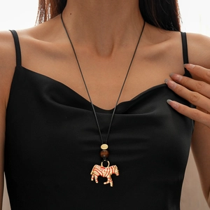 Detail of a zebra pendant necklace with red stripes and dark wooden beads on cord