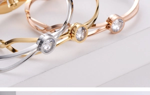 Macro shot of minimalist titanium steel bangles in gold, silver, and rose gold with zircon