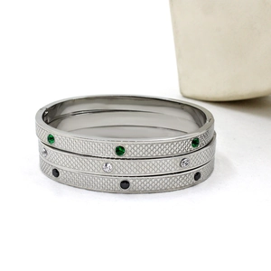 Detail of silver stainless steel bangles with scale texture and inset zircons