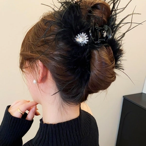 Détail d'une pince à cheveux en plumes de luxe avec cristal goutte sur une base noire