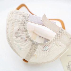 Dettaglio cappellino in rete traspirante per bambini con chiusura a velcro bianca