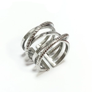Close-up of a multi-layer crisscross stainless steel ring with twisted rope texture