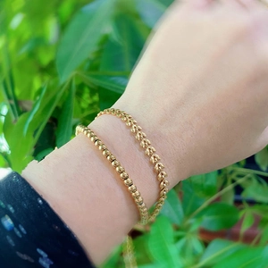 French style gold wheat leaf and bead bracelets layered set on female wrist