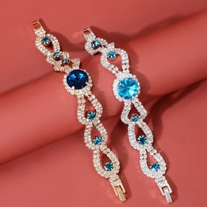 Detailed view of gold and silver teardrop crystal bracelets with blue rhinestones