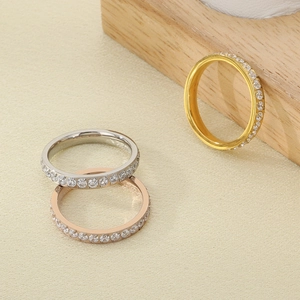 Close-up of three sparkling eternity rings in silver, rose gold, and gold on wooden display